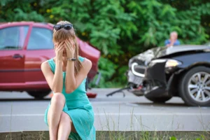 upset woman in front of car accident